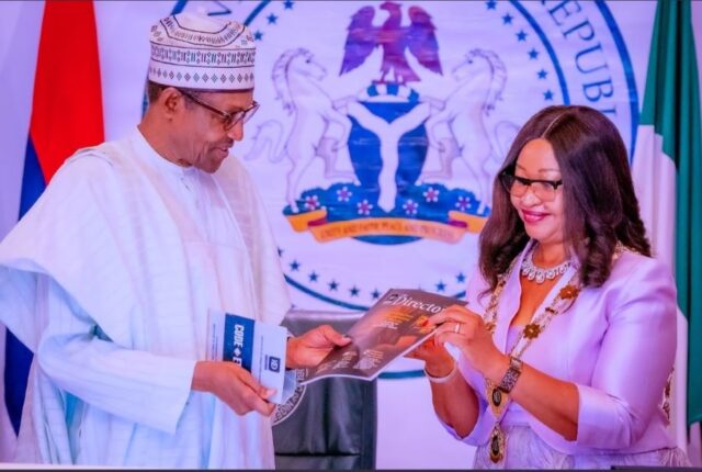 Former President Muhammadu Buhari recieving a presentation from IoD President and Chairman, Dr. Ije Jidenma