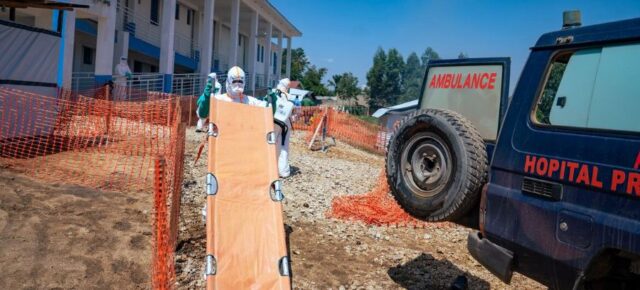 A health worker carries a stretcher into an Ebola treatment centre in the DR Congo